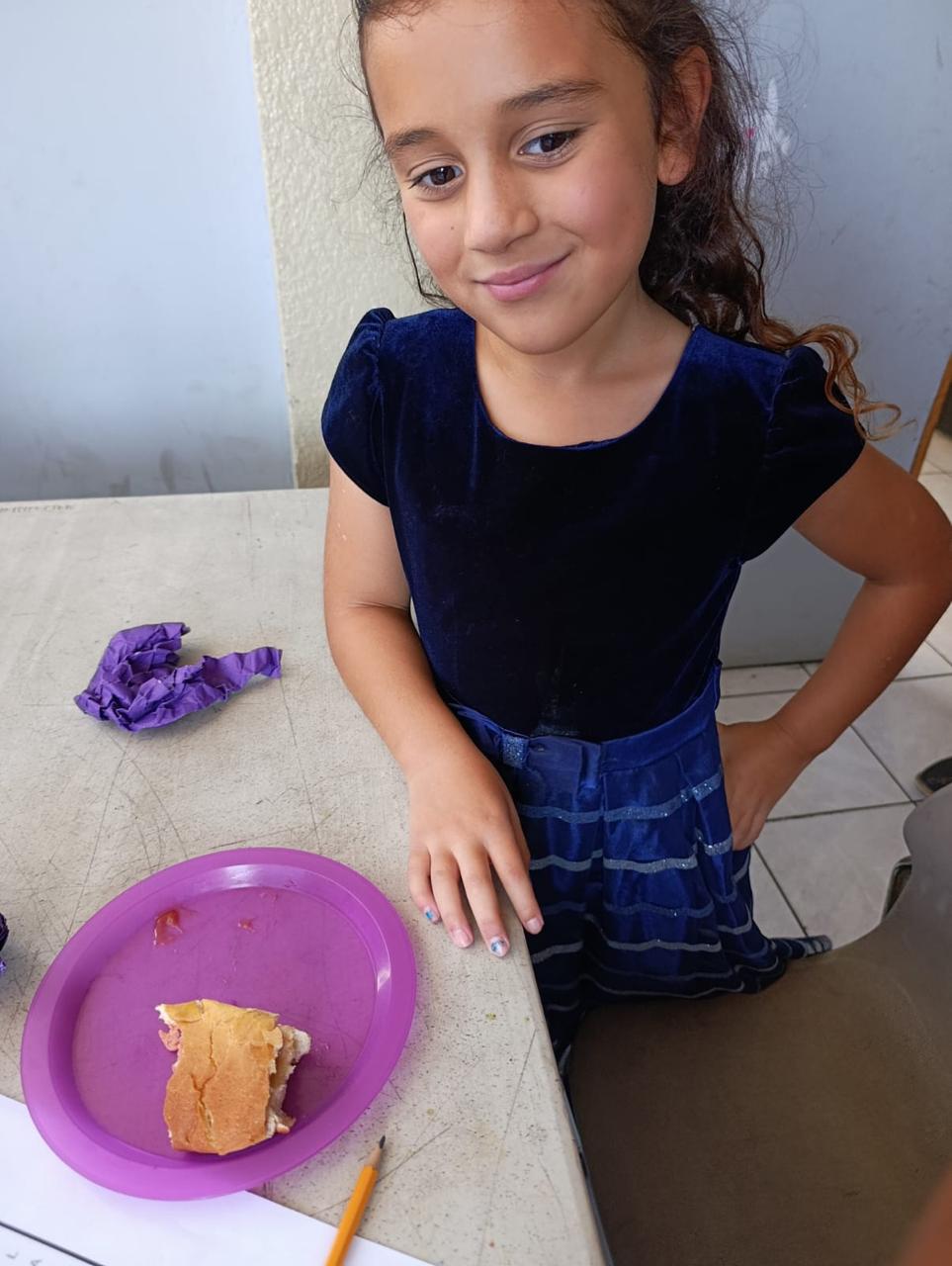 Niña sonriendo con su merienda